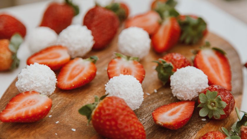 sliced strawberries on a brown wooden chopping board