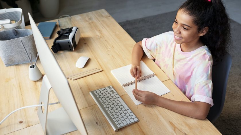 girl in pink t shirt looking at the imac