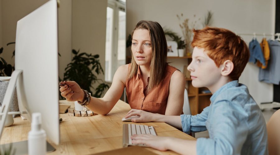photo of woman tutoring young boy