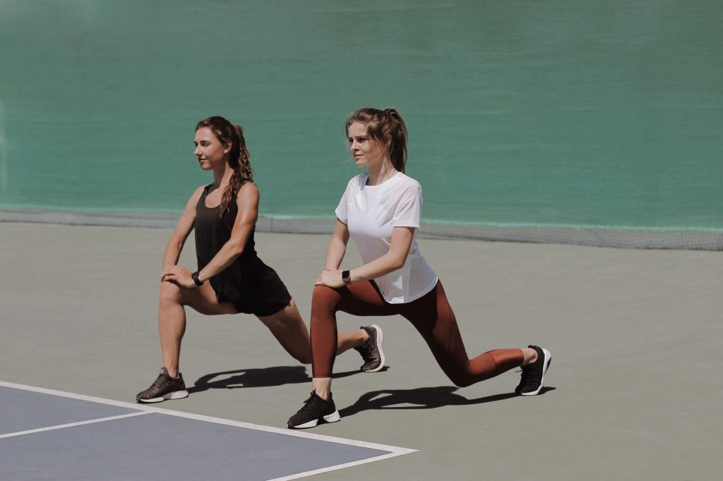 pretty women stretching in the athletic field