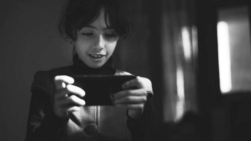 grayscale photography of girl using smartphone