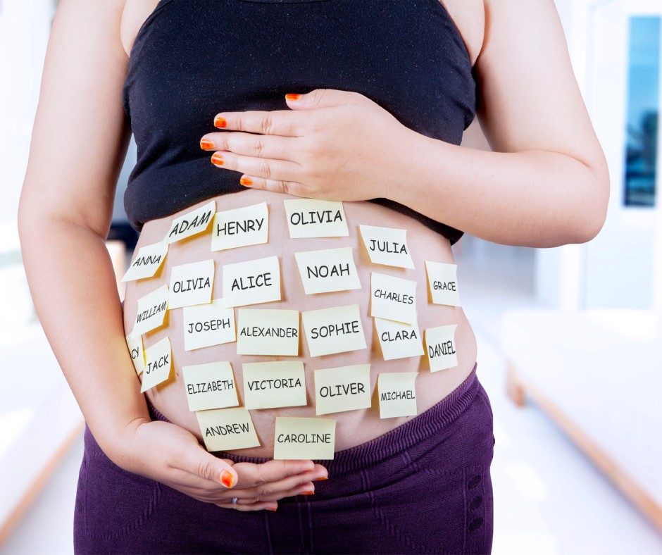 Closeup of a woman holding her pregnant belly that is covered with yellow post-it notes with different name options.