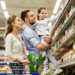 A young family—a father, mother, and daughter—shopping for essential grocery items at the store together.